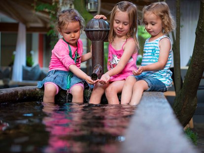 Familienhotel - Spielplatz - Kinder am Brunnen - ULRICHSHOF Nature · Family · Design