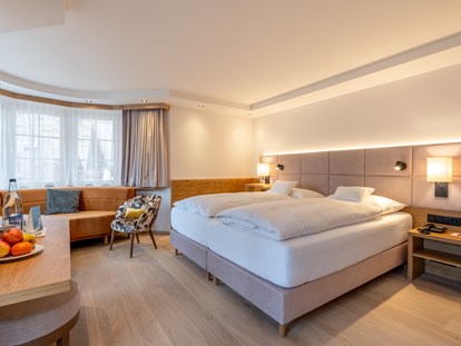 Familienhotel - Pools: Infinity Pool - Schweiz - Zimmer Fletschhorn mit gemütlicher Sitzecke.  - Resort La Ginabelle