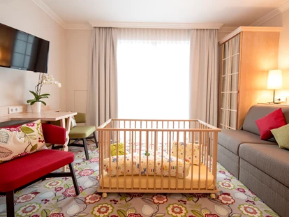Familienhotel - Babybetreuung - Unterkremsbrücke - Familienzimmer - Wohnbereich mit Gitterbett - Hotel Felsenhof