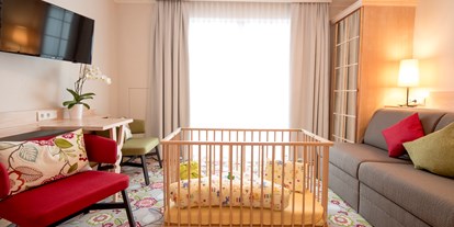 Familienhotel - Suiten mit extra Kinderzimmer - Familienzimmer - Wohnbereich mit Gitterbett - Hotel Felsenhof
