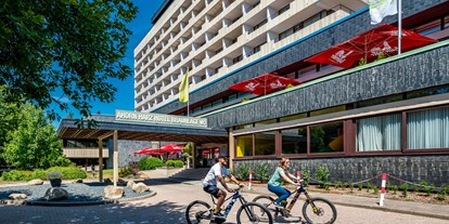 Familienhotel - Einzelzimmer mit Kinderbett - Duderstadt - Außenansicht Hotel mit Fahrrädern - AHORN Harz Hotel Braunlage