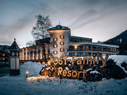 Familienhotel - Ausritte mit Pferden - Außenansicht Winter - POST Family Resort
