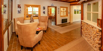 Familienhotel - Suiten mit extra Kinderzimmer - Ossiach - Rezeptionsbereich mit freundlichen, ugemütlichen Ausstattungen aus Holz - Familienhotel Schneekönig