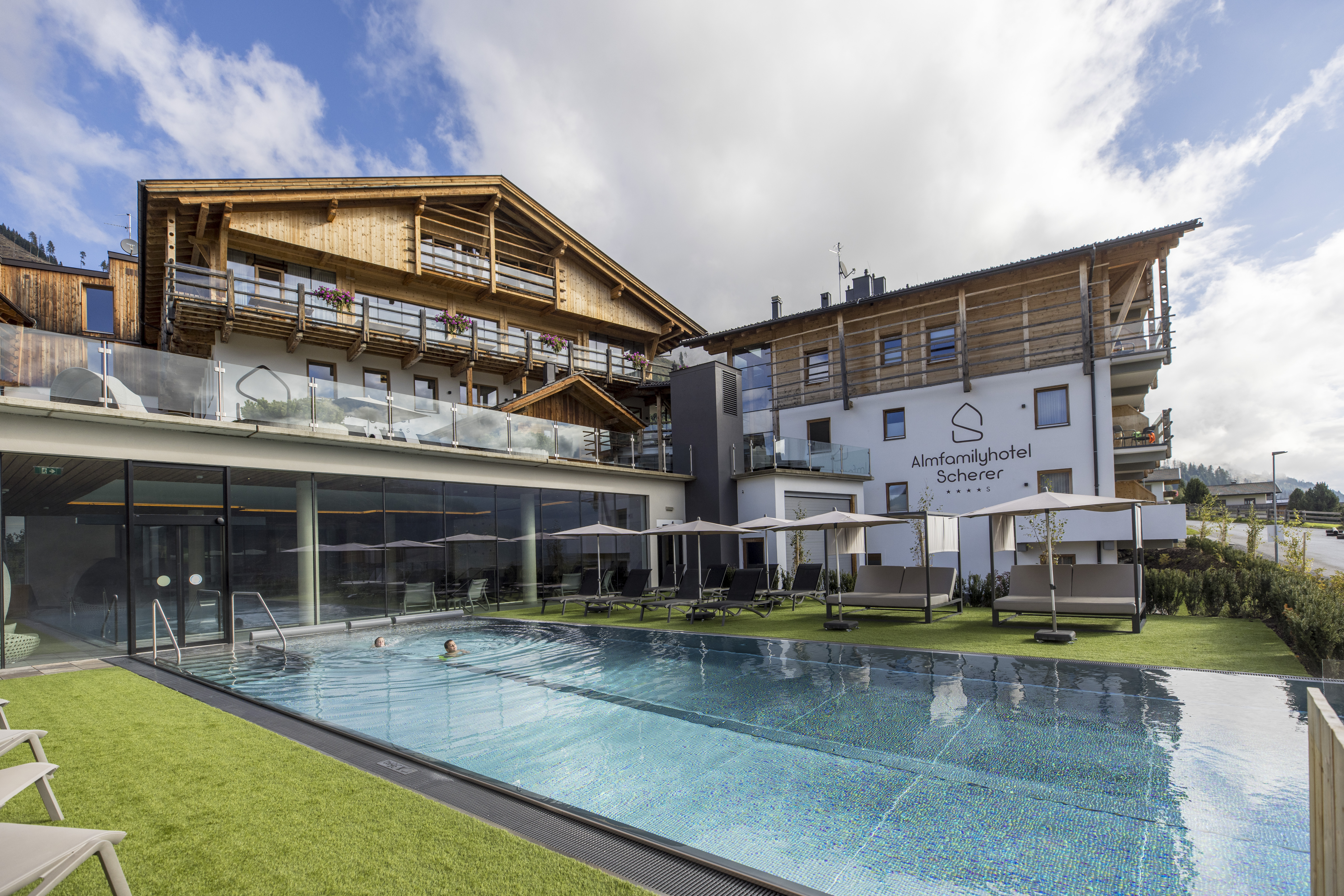 Kinderhotel - Außenansicht. Pool. Infinitypool. Liegewiese. Sommer. - Almfamilyhotel Scherer****s - Familotel TIROL