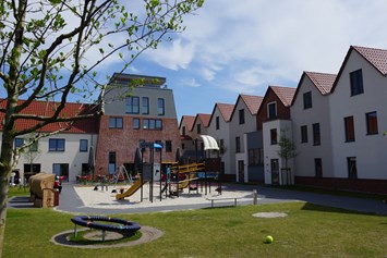 Kinderhotel: Innenhof mit Spielplätzen und großer Terrasse - Hotel Deichkrone - Familotel Nordsee