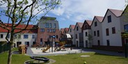 Familienhotel - Norden - Innenhof mit Spielplätzen und großer Terrasse - Hotel Deichkrone - Familotel Nordsee