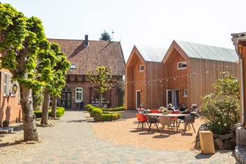 Kinderhotel: Innenhof mit den Cabins und dem Bauernhaus - Familotel Landhaus Averbeck