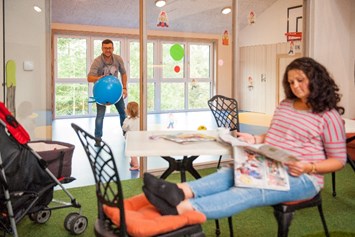 Kinderhotel: Papa dribbelt mit der Kleinen im Turnhällchen, Mama entspannt endlich mal im Elternbistro - Familotel Landhaus zur Ohe
