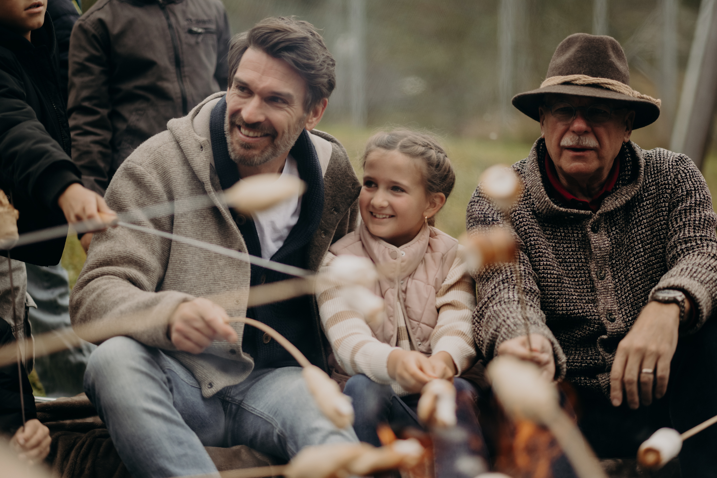 Familienhotel - Kinderbetreuung - Spittal an der Drau - Gemeinsame Momente am Lagerfeuer: Beim Stockbrotbacken erleben Kinder, Eltern und Großeltern unvergessliche Familienzeit in herzlicher Atmosphäre – ein Urlaubserlebnis für alle Generationen im Hotel Sonngastein. - Hotel Sonngastein