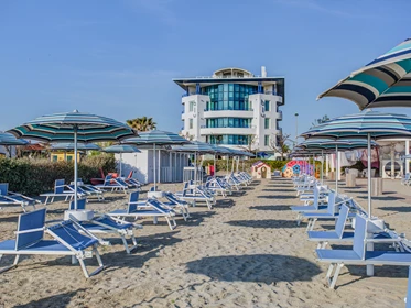 Kinderhotel: Privater Strand dem Hotel gegenueber mit Sonnenschirmen und Liegen zur Verfuegung - Blu Suite Hotel