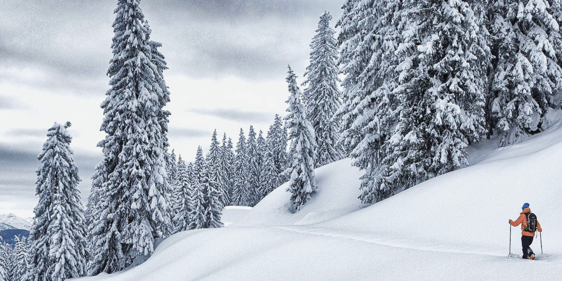 Familienhotel - Hallenbad - Hintersee (Hintersee) - Ein Wanderer mit Schneeschuhen geht durch den tief verschneiten Winterwald am Hochkönig – stille Natur und pure Erholung in Maria Alm. - die HOCHKÖNIGIN Mountain Resort