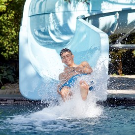Kinderhotel: Kinderpool mit 35 m Wasserrutsche im Garten - Feldhof DolceVita Resort
