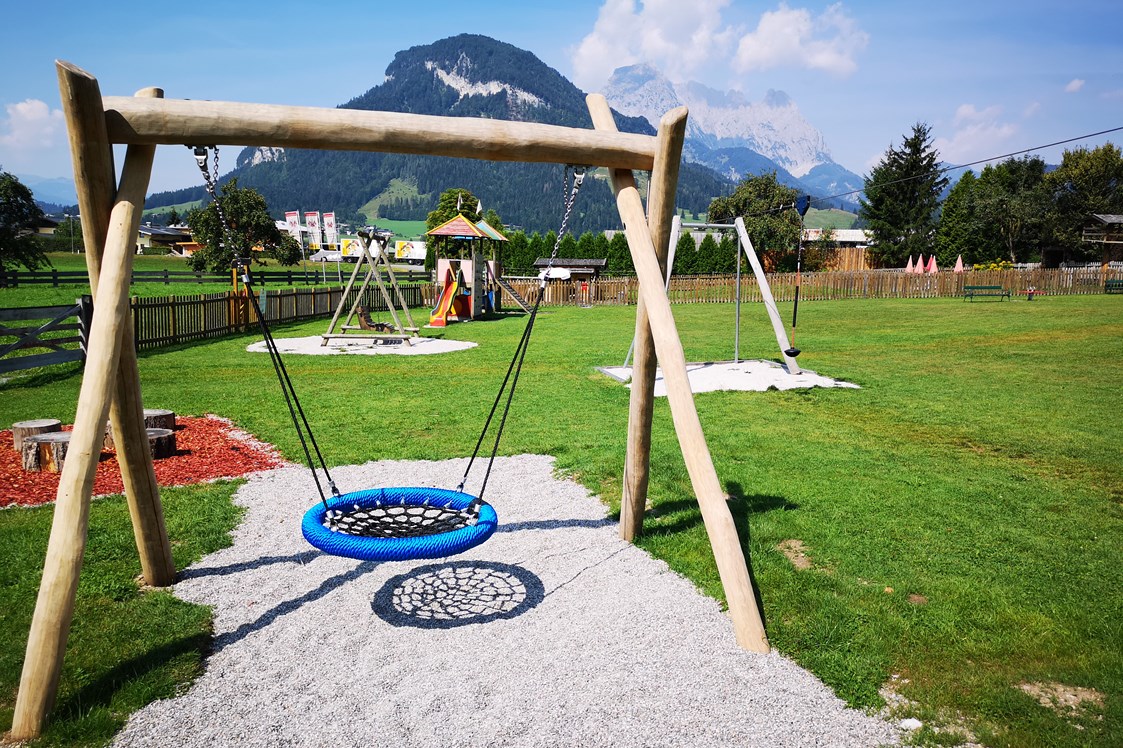 Kinderhotel: Freie Benützung der unmittelbar angrenzenden Spielwiese mit Nestschaukel, Seilrutsche, Spielturm und Trampolin - Hotel babymio