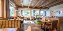 Familienhotel - Tirol - Speisessaal mit Kindersitzen, Wippen, Malsets, Kinderteller und Besteck, Kinder-Saftbrunnen - Hotel babymio