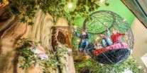 Familienhotel - PLZ 7032 (Schweiz) - Ein riesiger Baum im Märchenland lädt zum entdecken ein. Hängebrücken, Kugelbahnen, Vogelnester, begehbares Puppenhaus und vieles mehr. - Märchenhotel Braunwald