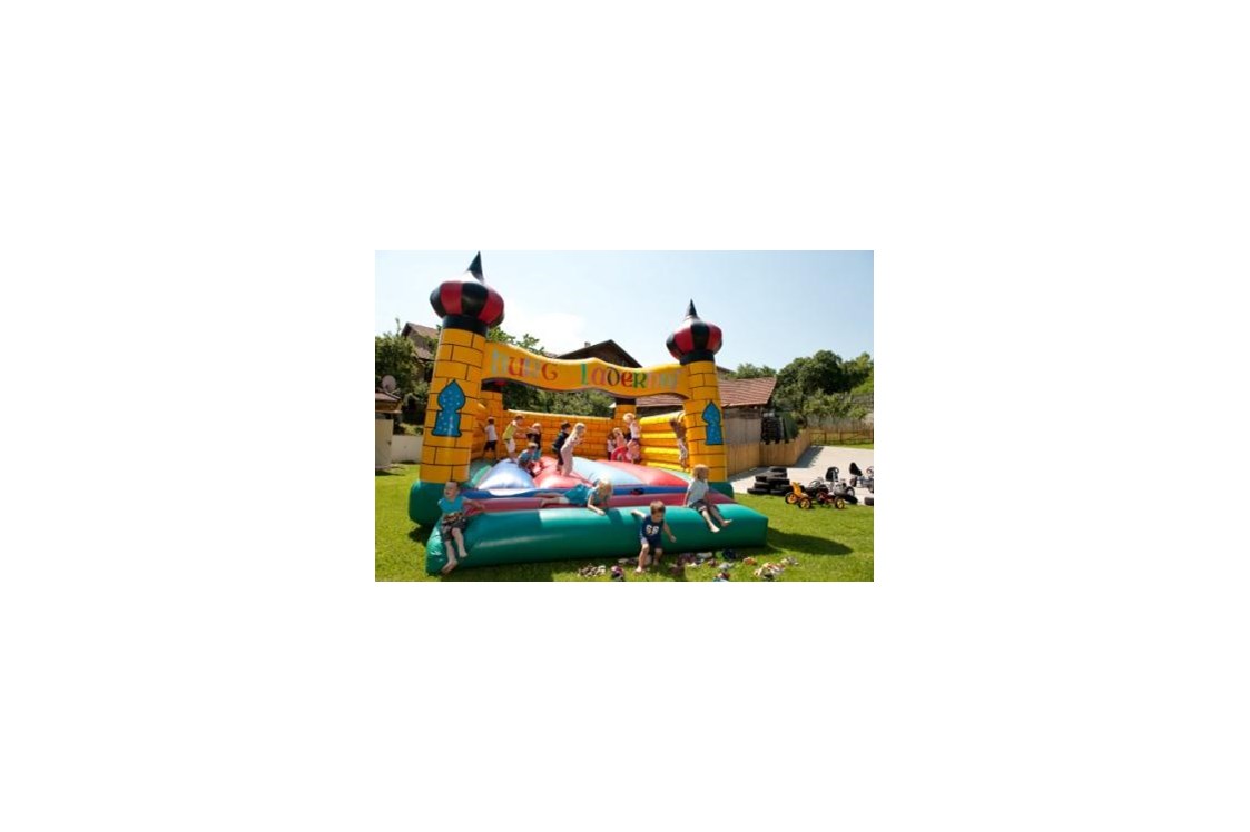 Kinderhotel: Auf dem Spielplatz toben sich die Kinder in der Hüpfburg aus - Kinderhotel Laderhof