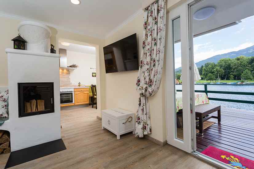 Kinderhotel: Kuscheliges Wohnzimmer mit Kaminofen, Terrasse und Seeblick - Smiley’s Kinderhotel 