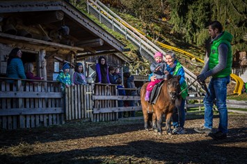 Kinderhotel: Pony Reiten am Streichelzoo direkt im Hotelgarten - Alpin Family Resort Seetal