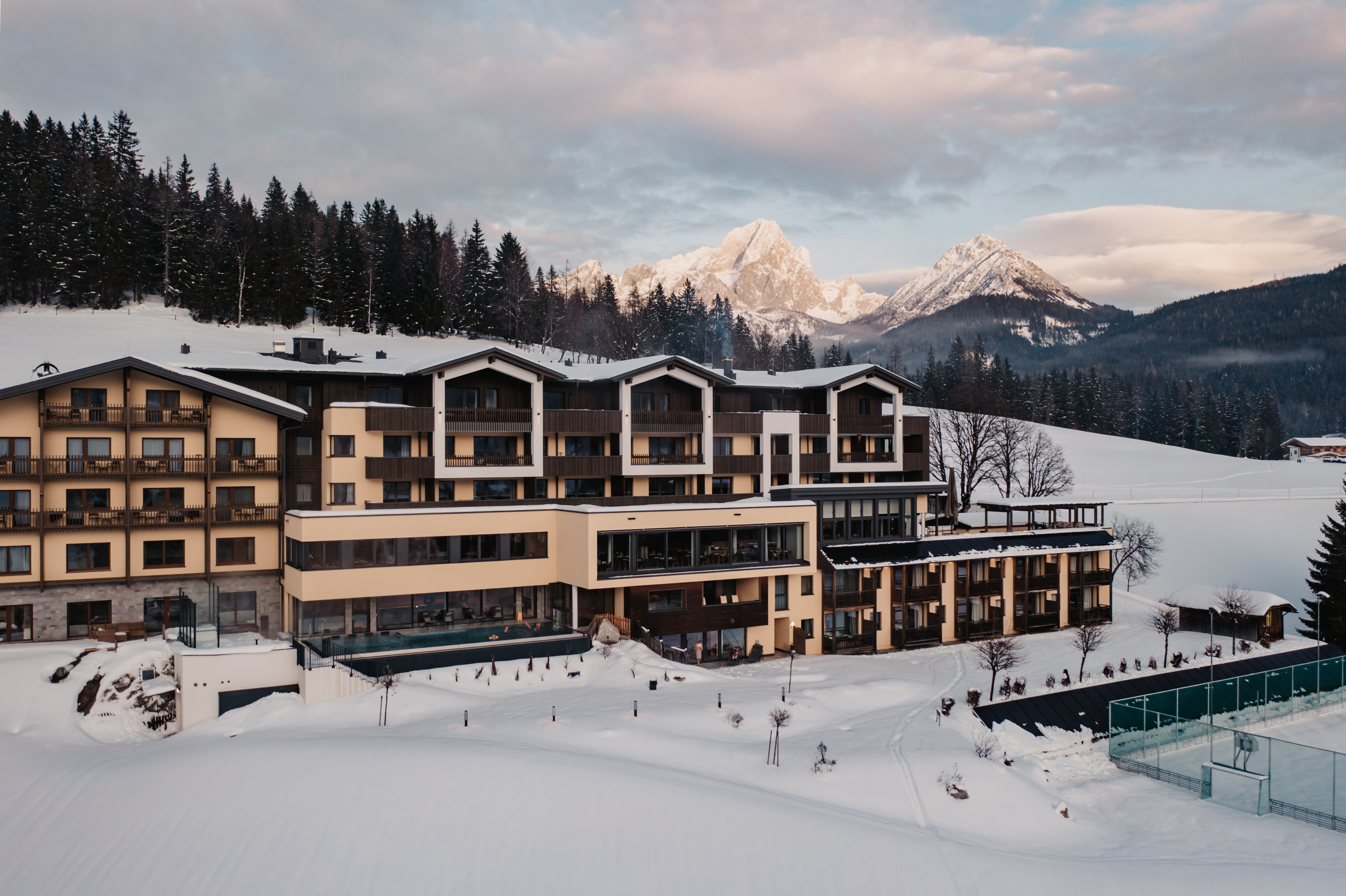 Kinderhotel: Mitten in der beeindruckenden Alpenlandschaft von Filzmoos liegt der gemütliche Hotel Neubergerhof. Das Bild zeigt das Hotel vor einer spektakulären Bergkulisse – ein perfekter Ort für Erholung und Naturerlebnisse. - Hotel …mein Neubergerhof****