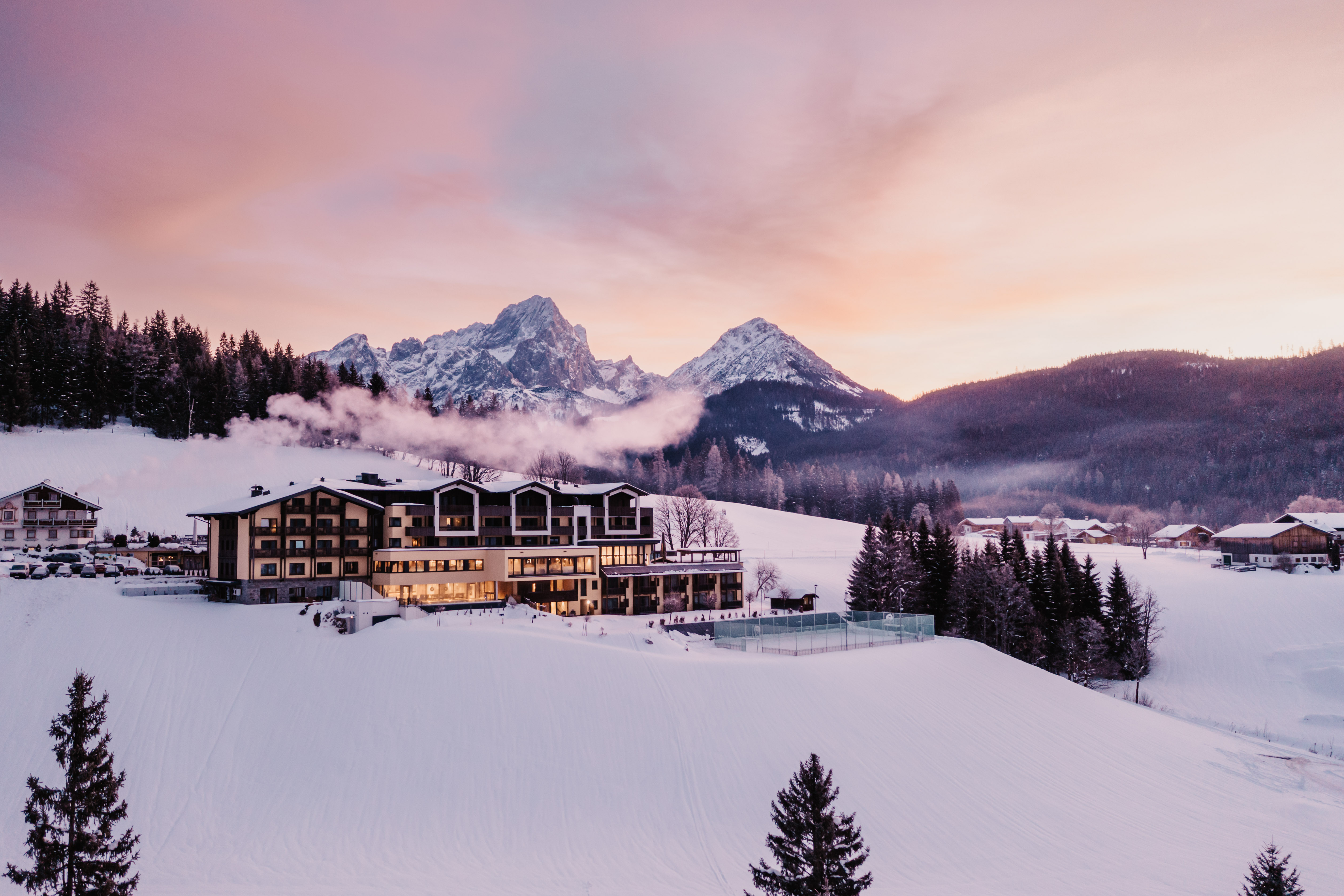 Kinderhotel: Vor der beeindruckenden Kulisse der Berge von Filzmoos präsentiert sich der charmante Hotel Neubergerhof. Umgeben von verschneiten Wiesen und frischer Bergluft verbindet das Bild Natur, Ruhe und alpinen Charme. - Hotel …mein Neubergerhof****S