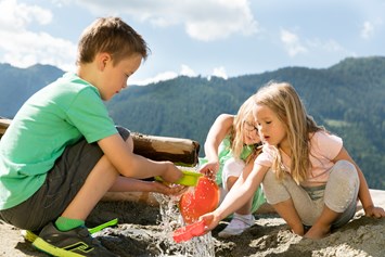 Kinderhotel: Kinder spielen bei der Wasserstation - Almfamilyhotel Scherer****s - Familotel Osttirol