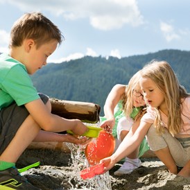 Kinderhotel: Kinder spielen bei der Wasserstation - Almfamilyhotel Scherer****s - Familotel Osttirol
